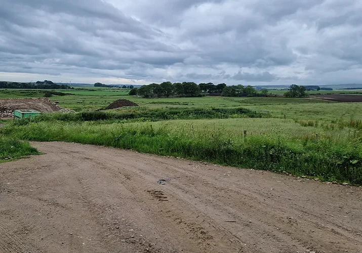an image of a dirt road leading to construction site in the countryside